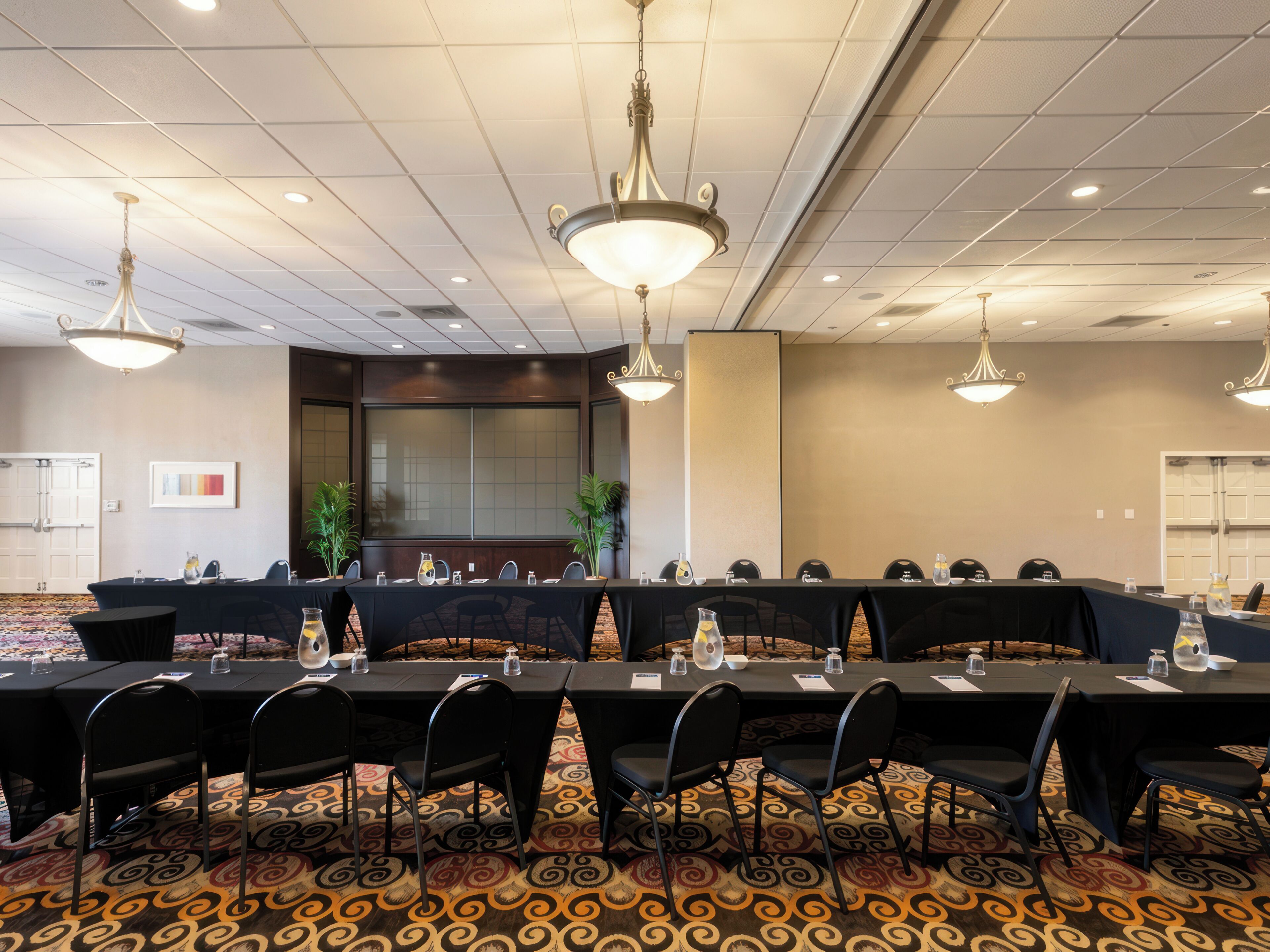 A conference room with a long table, chairs, and ceiling lights.