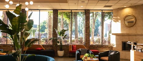 A modern lobby with a blue sofa, a wooden coffee table, and a fireplace.