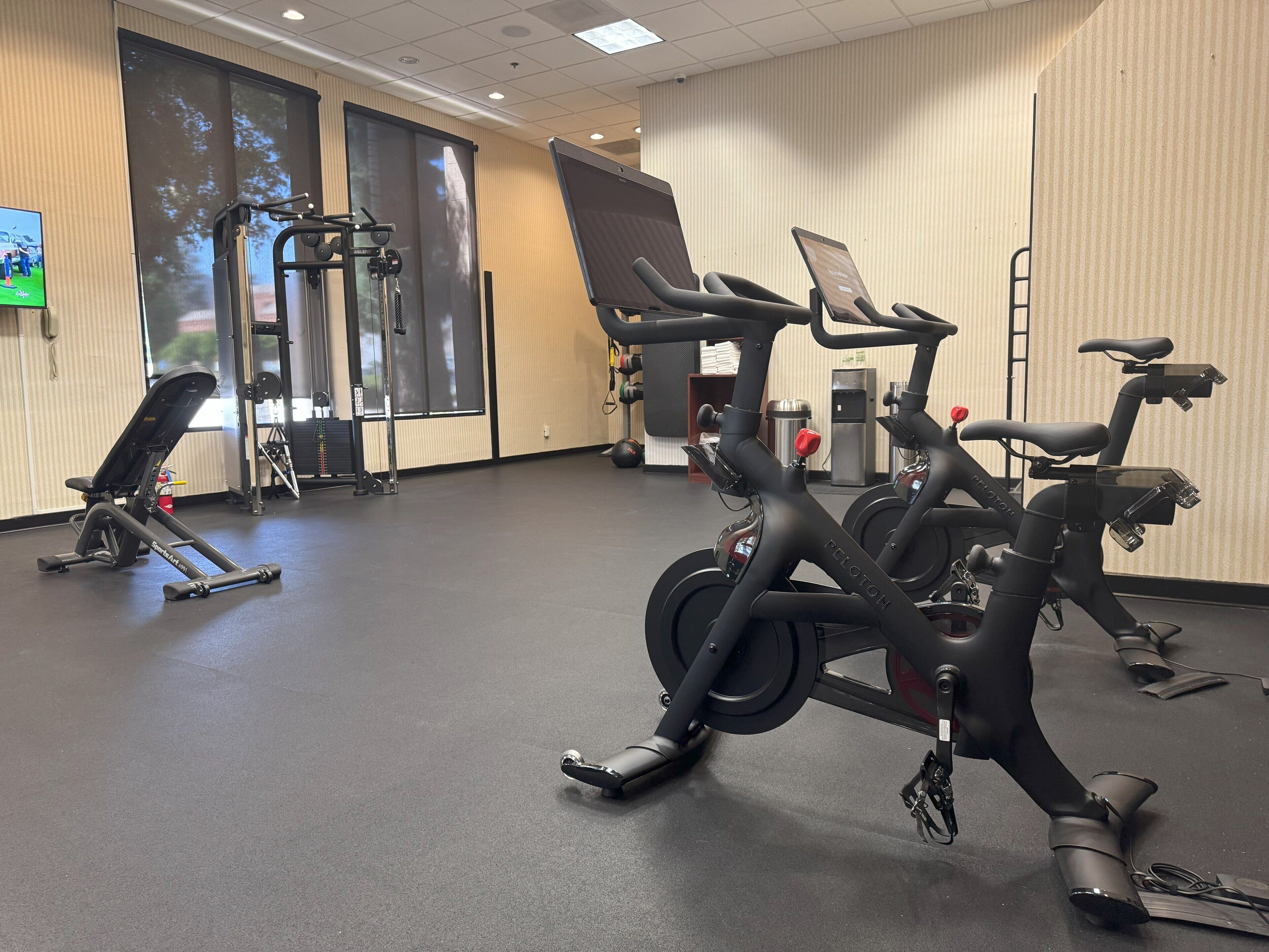 Ett gym med träningsutrustning, inklusive löpband, motionscyklar och en styrketräningsmaskin.