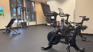 Ett gym med träningsutrustning, inklusive löpband, motionscyklar och en styrketräningsmaskin.