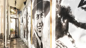 Un pasillo con una serie de murales blanco y negro en las paredes, suelo de hormigón y una puerta al final.