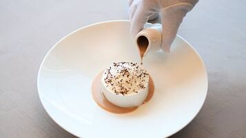 Un postre en un plato blanco, con salsa que se vierte sobre él.
