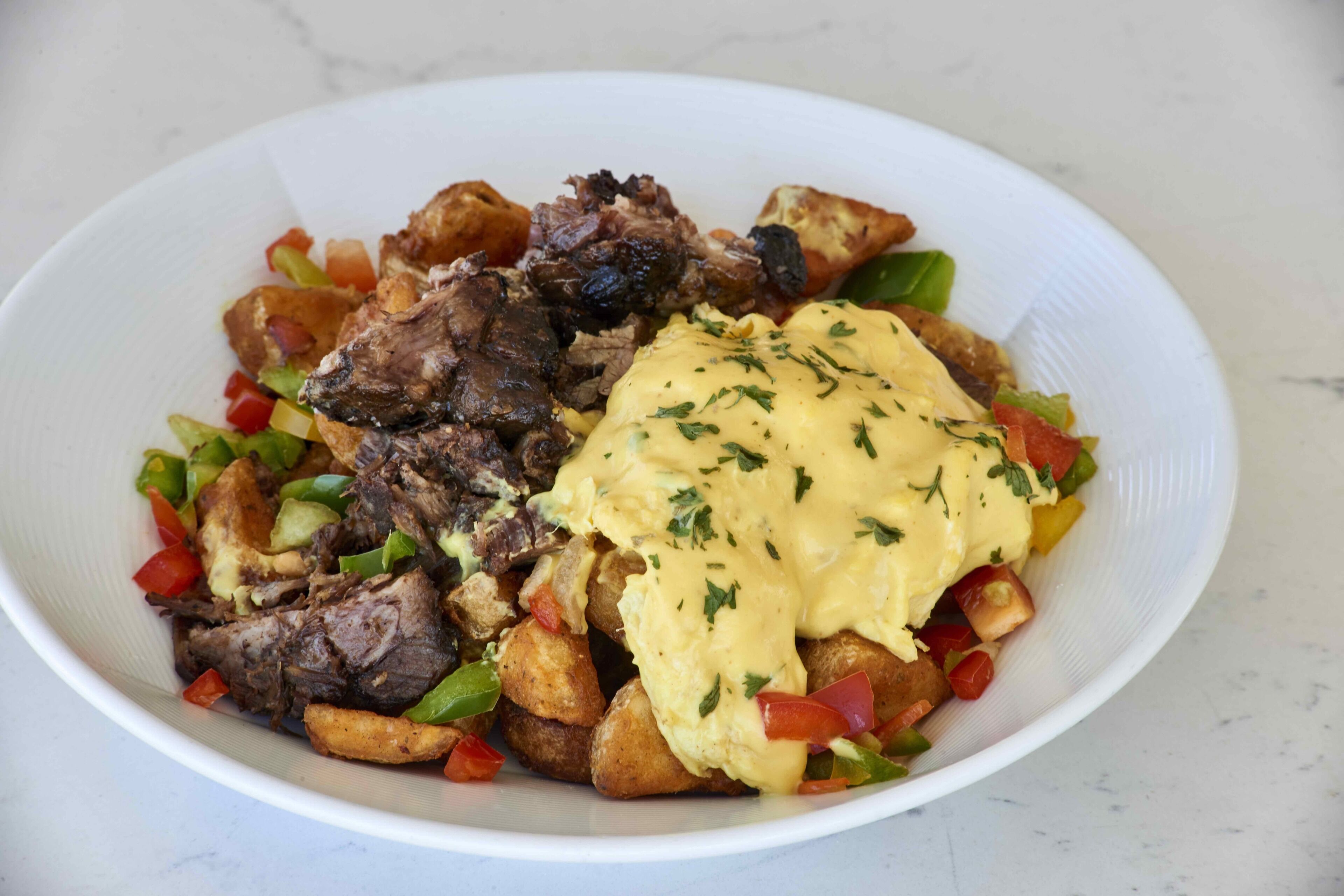 A plate of food with meat, potatoes, and a creamy sauce.