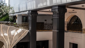 Un vestíbulo amplio con zona de bar, asientos y una columna decorativa grande.
