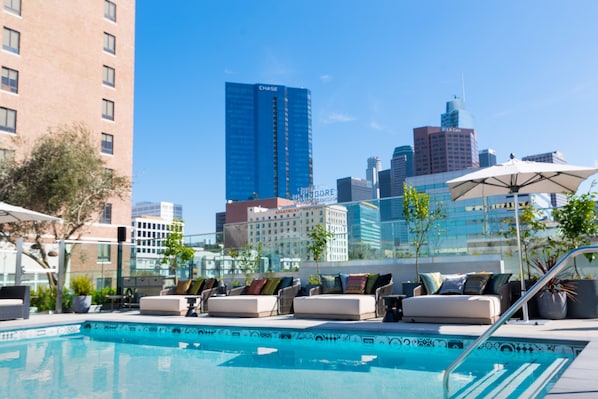 Una piscina al aire libre, camas de piscina gratis, sombrillas