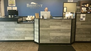 A reception desk with a sign reading "Baymont by Wyndham" and a "Manager on Duty" sign. - Baymont by Wyndham Bozeman (Bozeman)