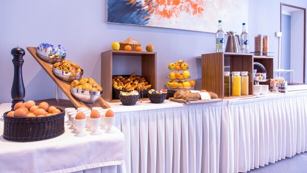 Disposição de buffet com diversos alimentos e bebidas.
