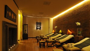 Um quarto com várias mesas de massagem, lareira e parede de madeira.
