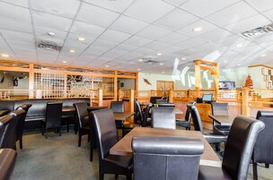 A restaurant interior with booths and tables, wooden decor, and a counter area.