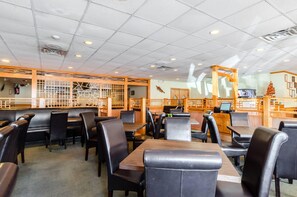 A restaurant interior with booths and tables, wooden decor, and a counter area.