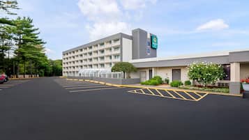Un hotel con estacionamiento, un edificio de varios pisos y un letrero que indica que es un Quality Inn.