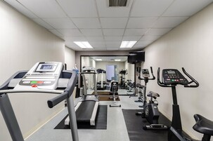 Un gimnasio con cintas de correr, elípticas y máquinas de pesas.