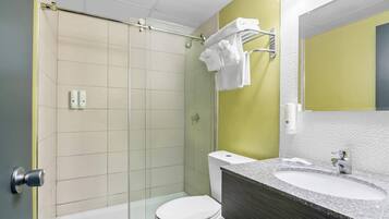 A modern bathroom with a shower, toilet, and sink.