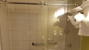 A shower with a glass door, a toilet, and a sink with a granite countertop. - Quality Inn West Springfield (West Springfield)