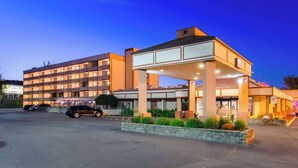 A hotel with a modern design, featuring a covered entrance and multiple floors.