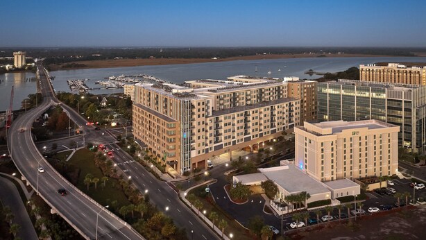 A multi-story hotel with a modern design, located near a marina with boats docked. -  Holiday Inn Express & Suites Charleston DWTN - Medical CTR by IHG (Charleston)