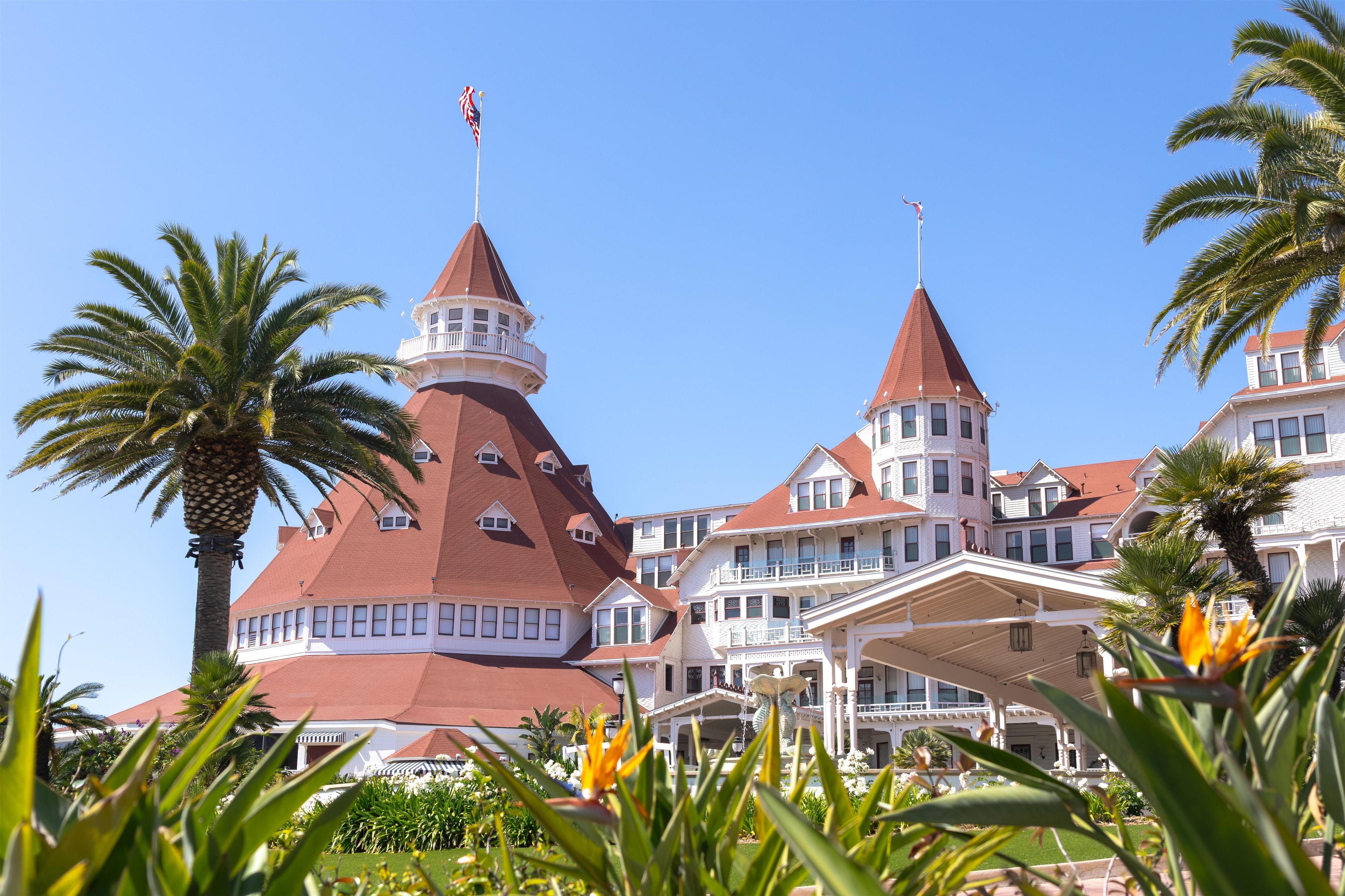Un grand hôtel composé de plusieurs tours, avec une cour intérieure et des palmiers.