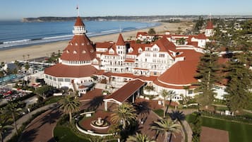 Een groot hotel met meerdere koepelvormige gebouwen, uitzicht op een strand en een aangelegde binnenplaats.