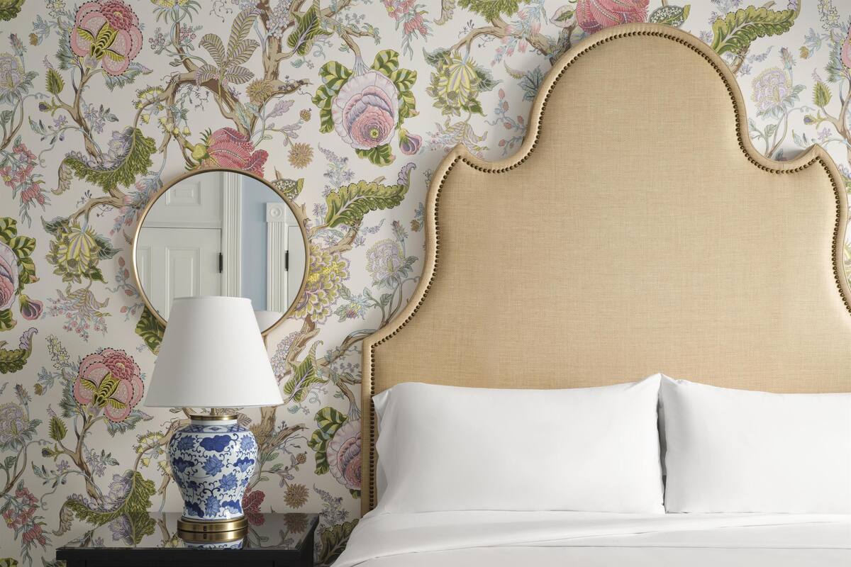 Un lit avec une tête de lit, une table de chevet avec une lampe et un miroir.