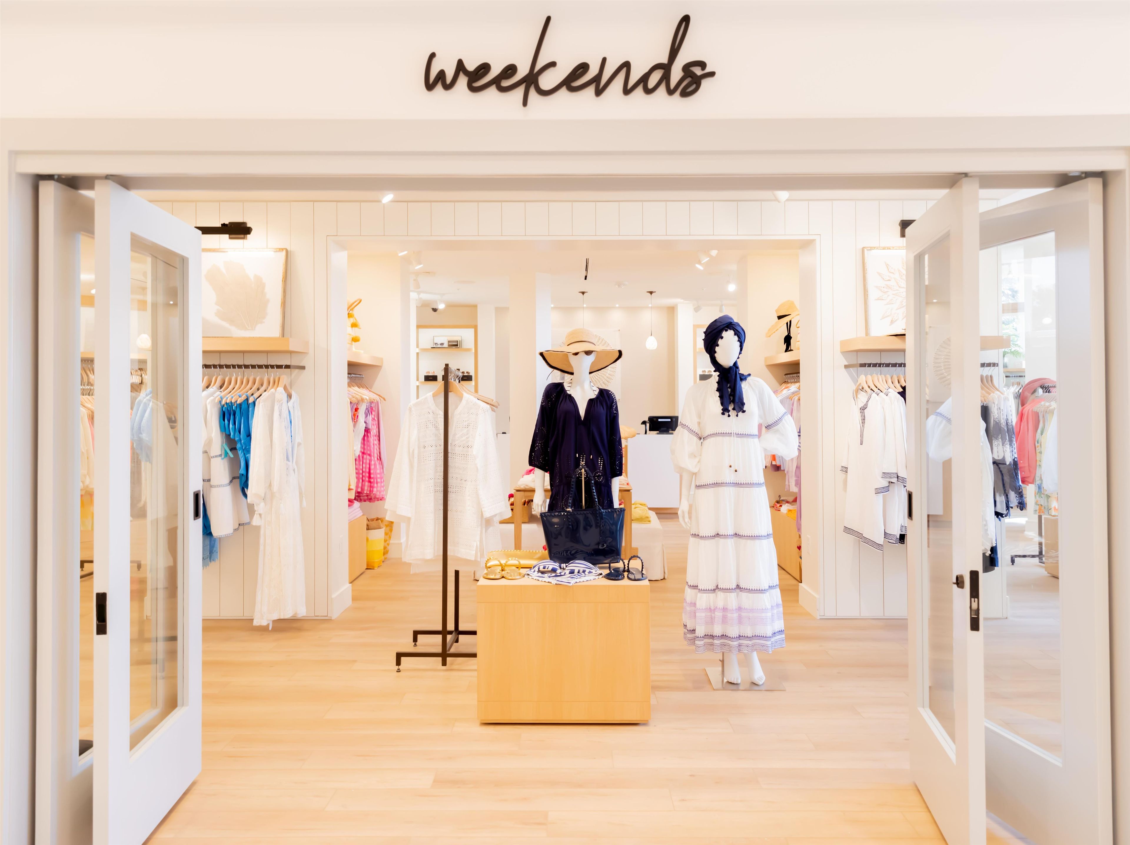 Une boutique de vêtements appelée « Weekends », avec des mannequins présentant différents ensembles vestimentaires et un comptoir en bois.