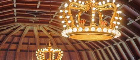 Un salón imponente con candelabros ornamentados y un techo alto y abovedado.