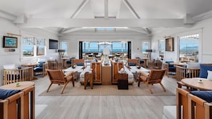A spacious room with a large dining table, multiple seating arrangements, and a view of the ocean. - Hotel del Coronado, Curio Collection by Hilton (Coronado)