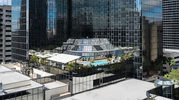 A modern hotel with a rooftop pool, surrounded by high-rise buildings.