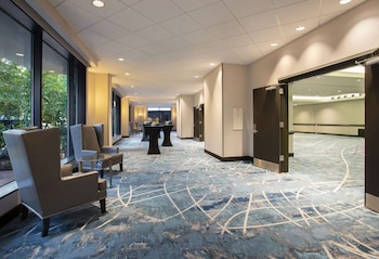 A gym with multiple treadmills lined up against the wall, a wooden floor, and a TV mounted on the wall. at Hilton Tampa Downtown