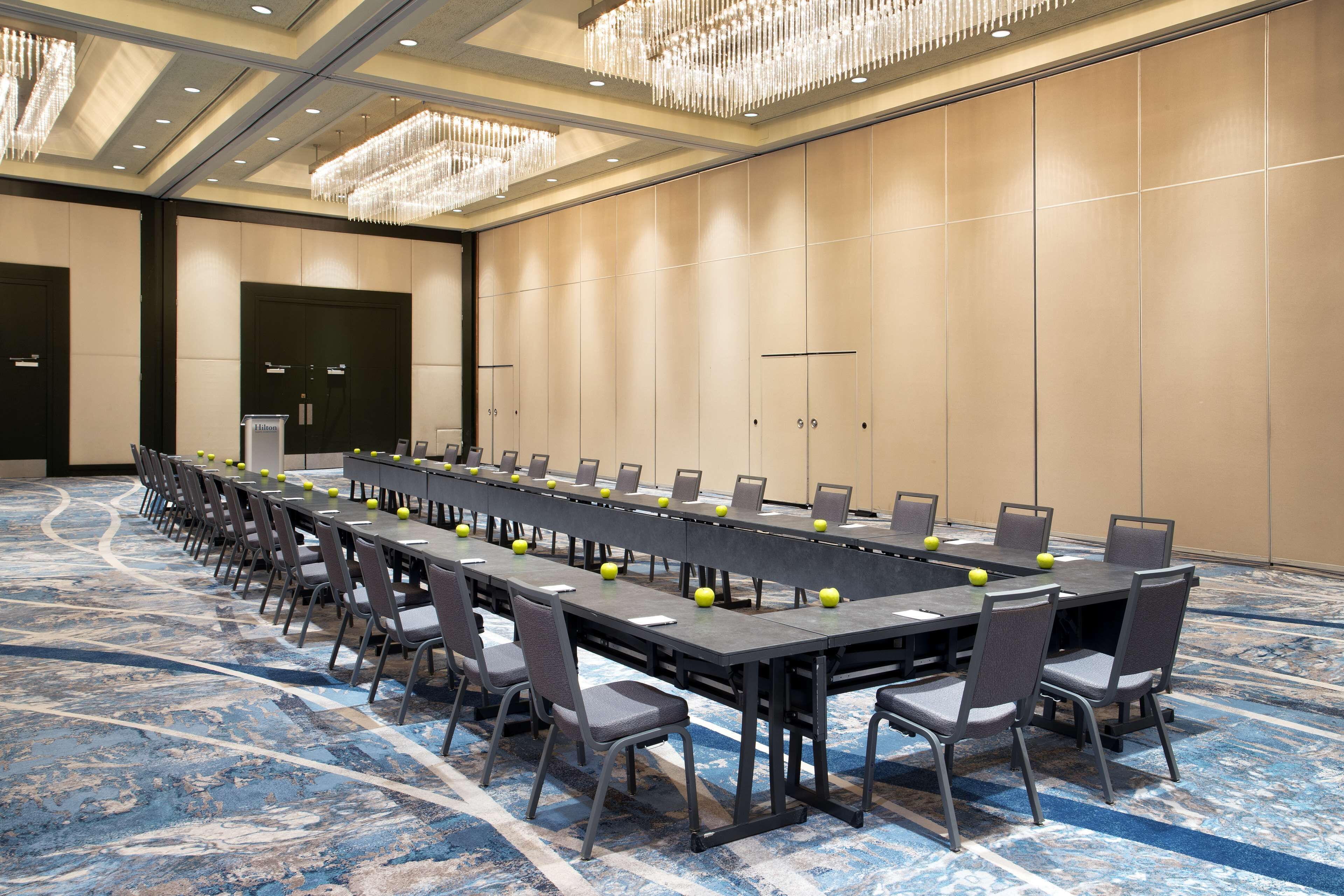 A conference room with a long table, chairs, and a podium.