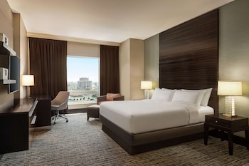 A hotel corridor with seating, a reception area, and a large mirror. at Hilton Tampa Downtown