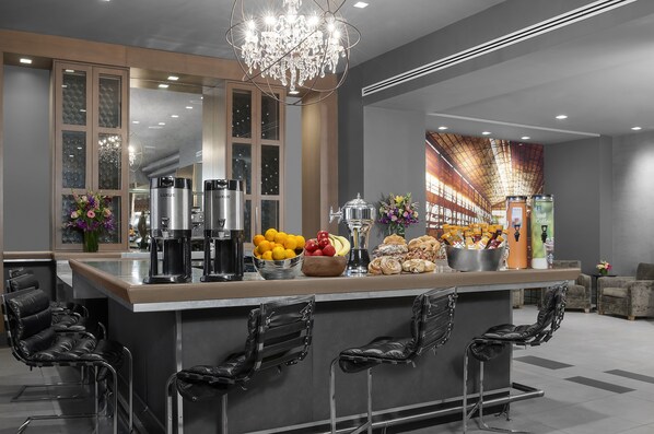 Cozinha moderna com espaço para bar, eletrodomésticos de aço inoxidável e um candelabro.