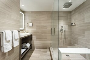 A modern bathroom with a glass-enclosed shower, a white sink, and a mirror. - Crowne Plaza Manhattan Times Square by IHG (New York)
