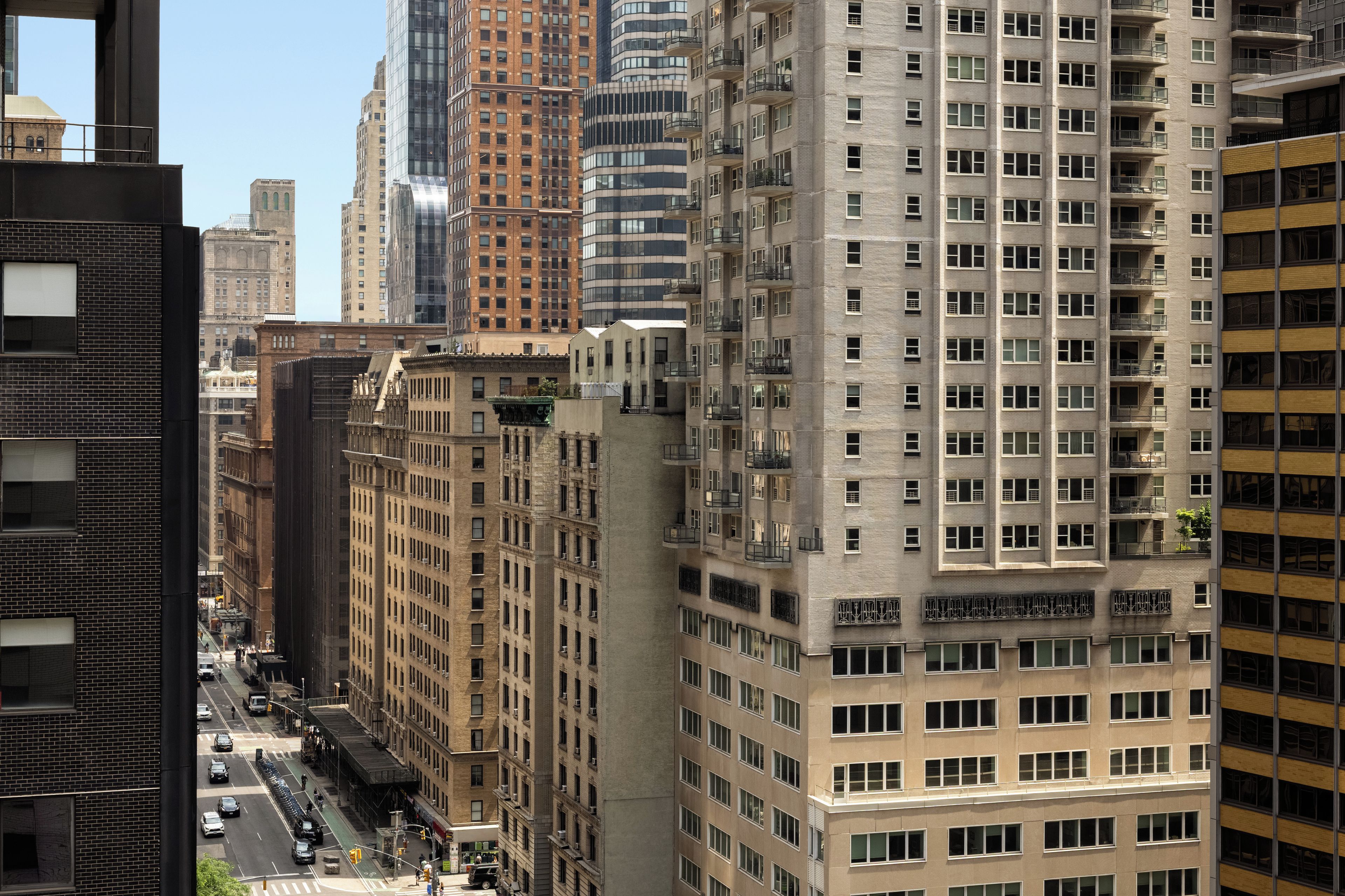 Un immeuble de grande hauteur, doté de nombreux étages et présentant une variété de styles architecturaux.