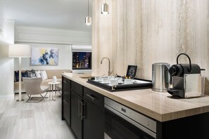 A modern kitchen with a built-in coffee machine, a kettle, and a coffee press on the counter. - Crowne Plaza Manhattan Times Square by IHG (New York)