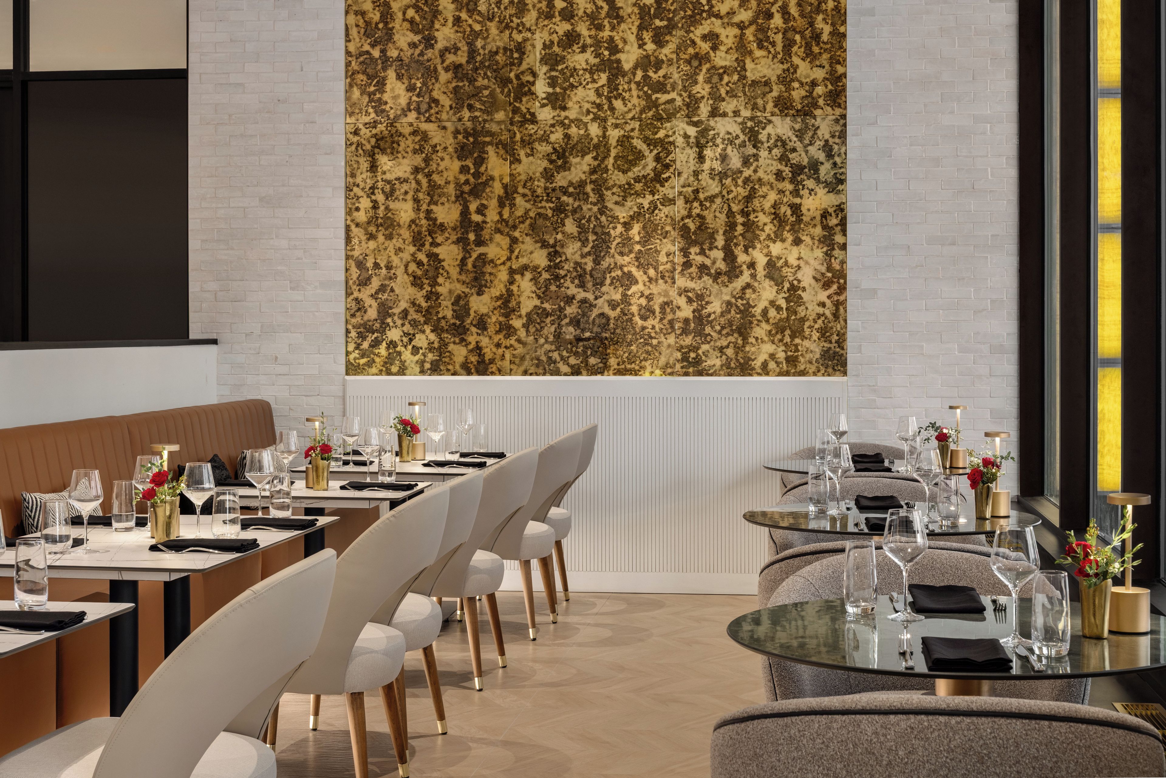 Un comedor moderno con una mesa larga, sillas, un banco y una gran obra de arte abstracto en la pared.