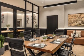A modern conference room with a long table, black leather chairs, and a large map on the wall. - Crowne Plaza Manhattan Times Square by IHG (New York)