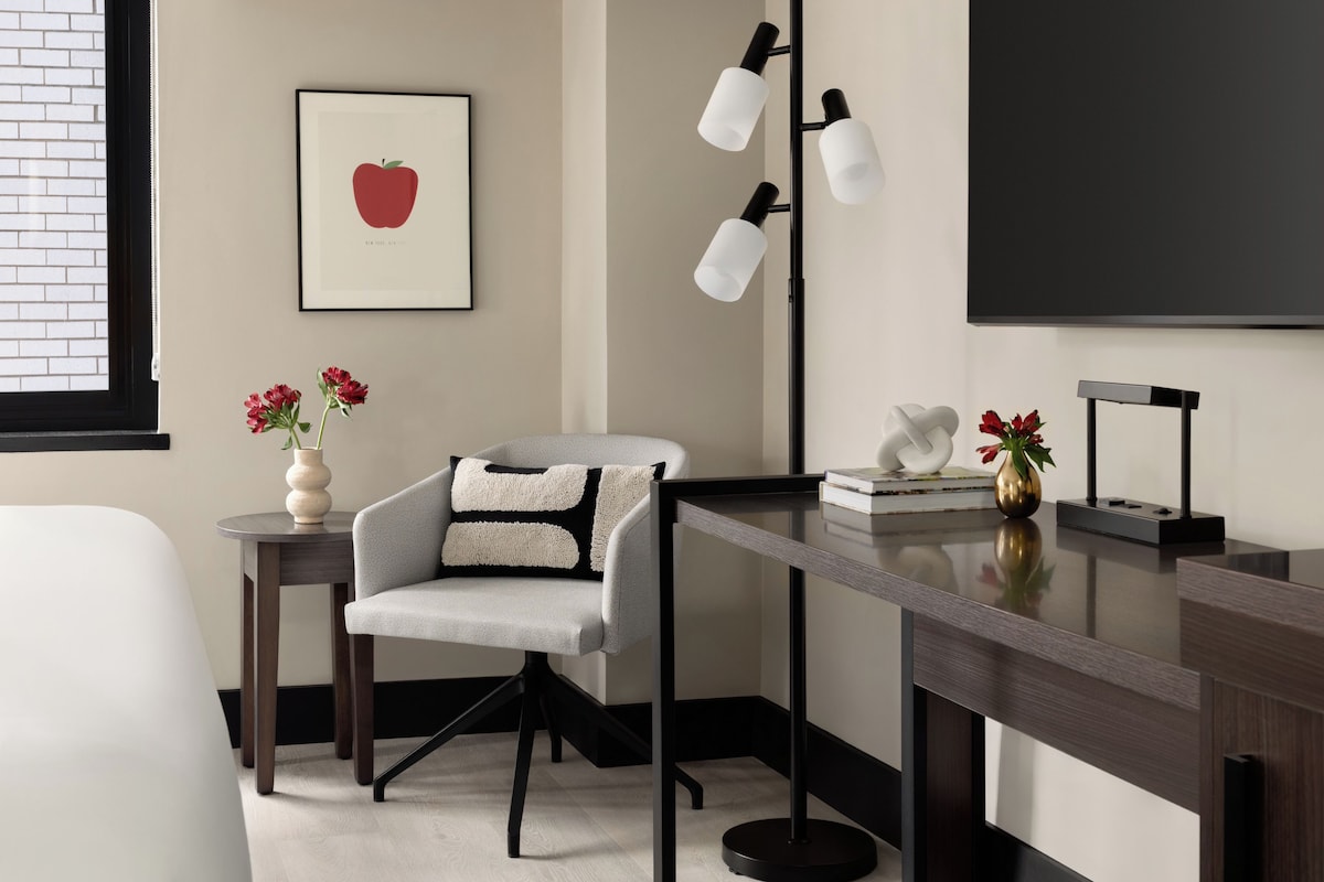 A modern office space with a desk, chair, and a framed picture on the wall.