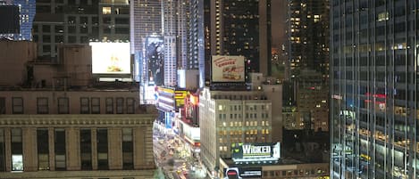A nighttime cityscape with illuminated billboards and buildings.