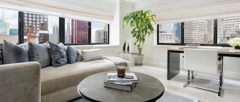 A modern living room with a sofa, coffee table, and a potted plant.