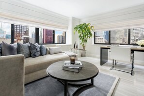 A modern living room with a sofa, coffee table, and a potted plant. - Crowne Plaza Manhattan Times Square by IHG (New York)