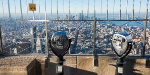 Two vintage coin-operated telescopes with a cityscape view in the background. - Crowne Plaza Manhattan Times Square by IHG (New York)