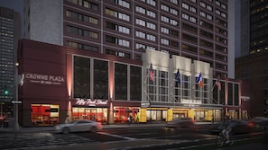 A multi-story hotel with a prominent entrance, large windows, and flags. - Crowne Plaza Manhattan Times Square by IHG (New York)