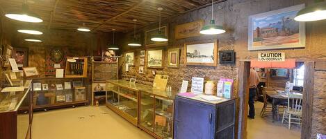 A rustic interior with wooden beams, framed pictures, and a caution sign.