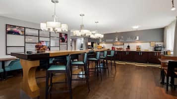 Une cuisine moderne dotée d’un îlot central, de tabourets de bar et de luminaires suspendus.