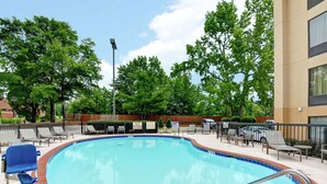A swimming pool with lounge chairs and a sign prohibiting smoking.