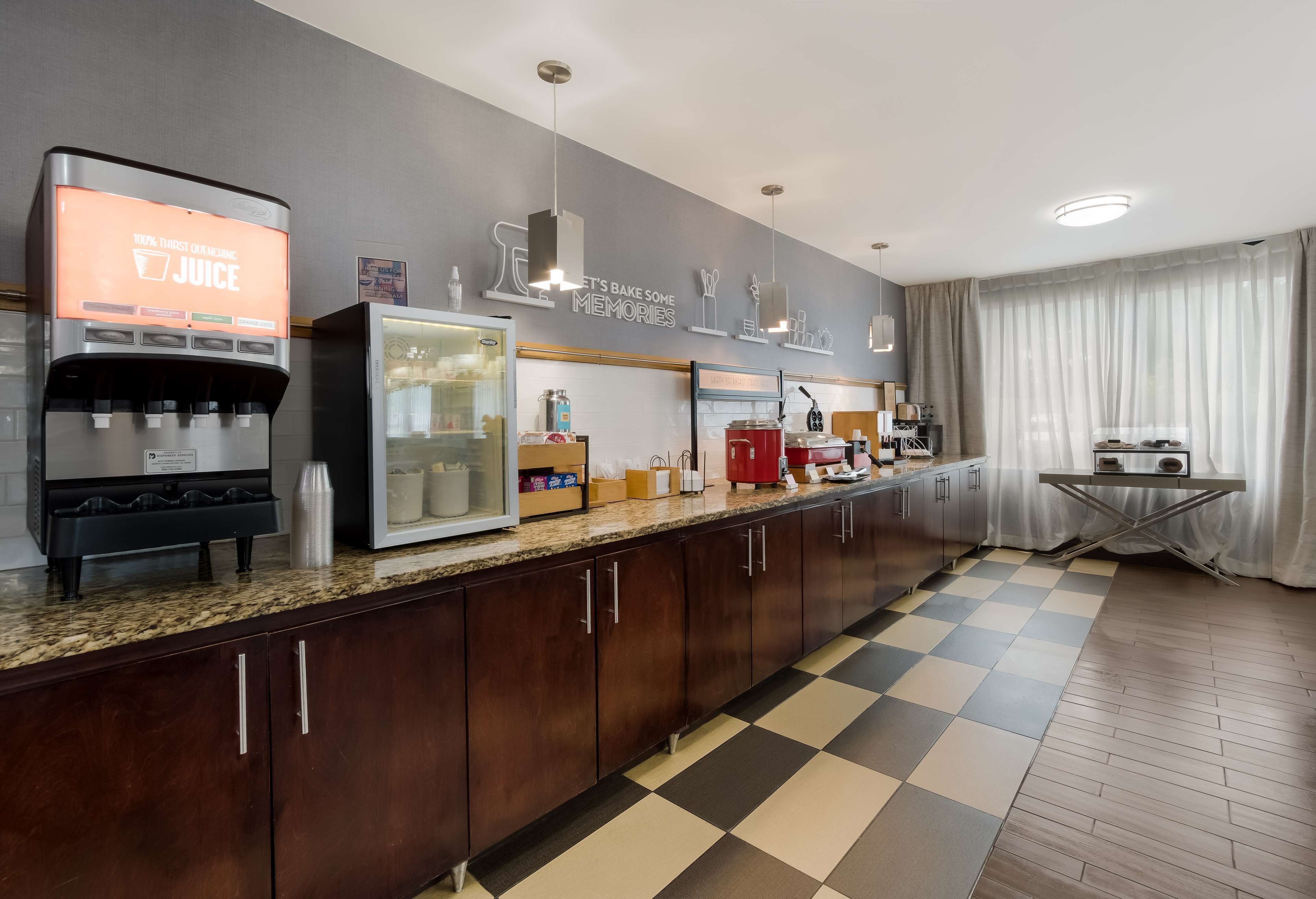 Una cocina moderna con dispensador de jugo, refrigerador y máquina de café.