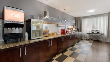 Una cocina moderna con dispensador de jugo, refrigerador y máquina de café.