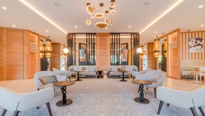 A modern lounge area with sofas, tables, and a patterned carpet. - Holiday Inn Nice-Port St Laurent by IHG (Saint-Laurent-du-Var)