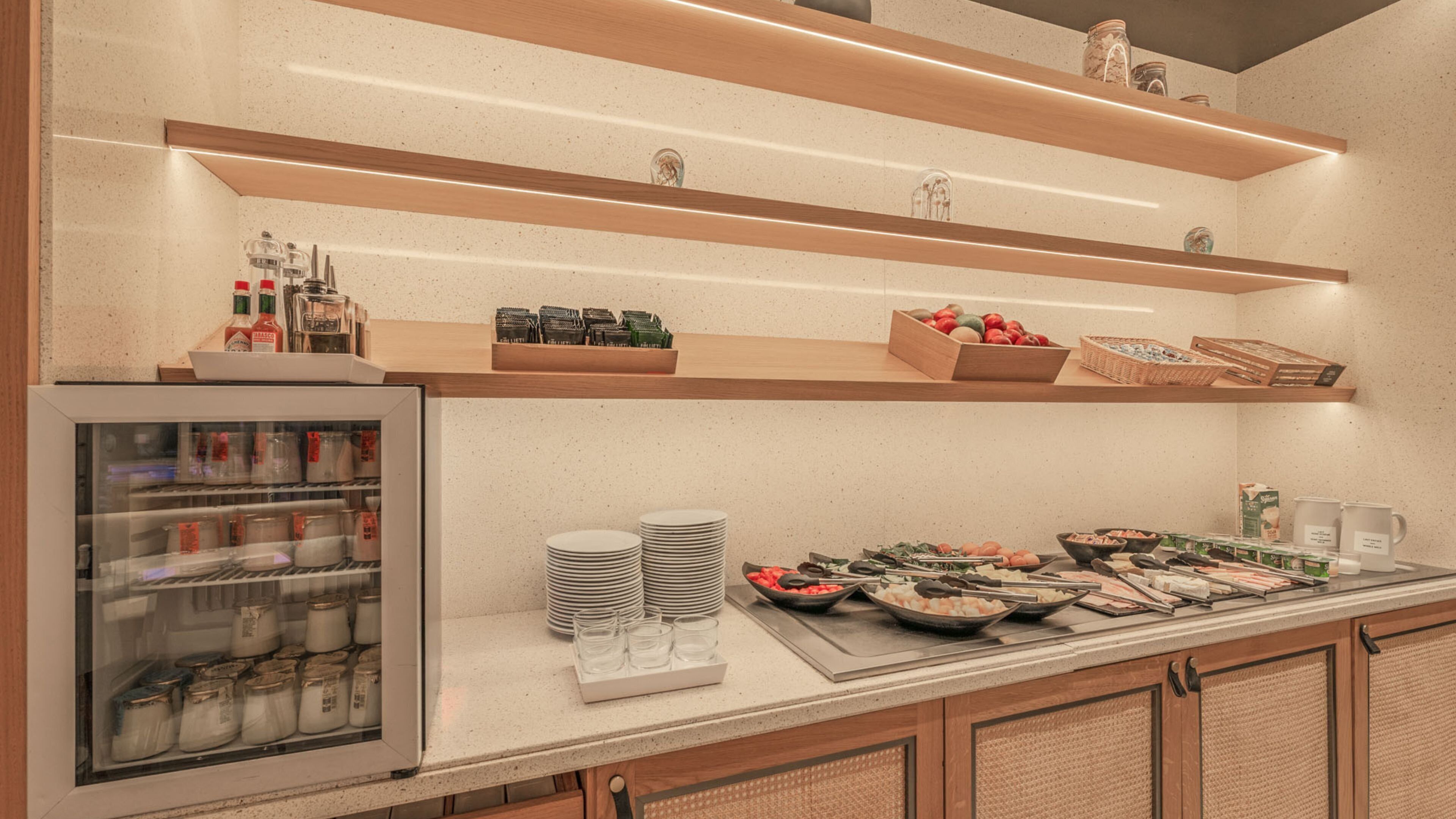 Uma mesa de buffet com diversos alimentos, acompanhamentos e bebidas.