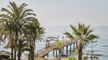 A wooden pier leading to a building labeled "MARDELLA CLUB" with a view of the sea.
